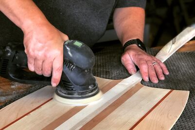 Person using an orbital sander on wood