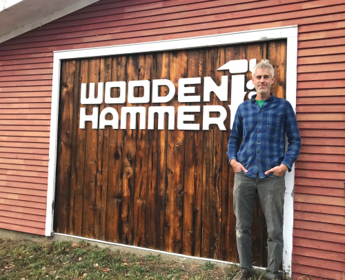 Ben Rafael standing in front of the Wooden Hammer sign