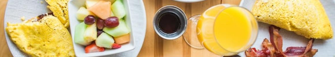 a variety of breakfast dishes on plates on a table as seen from above